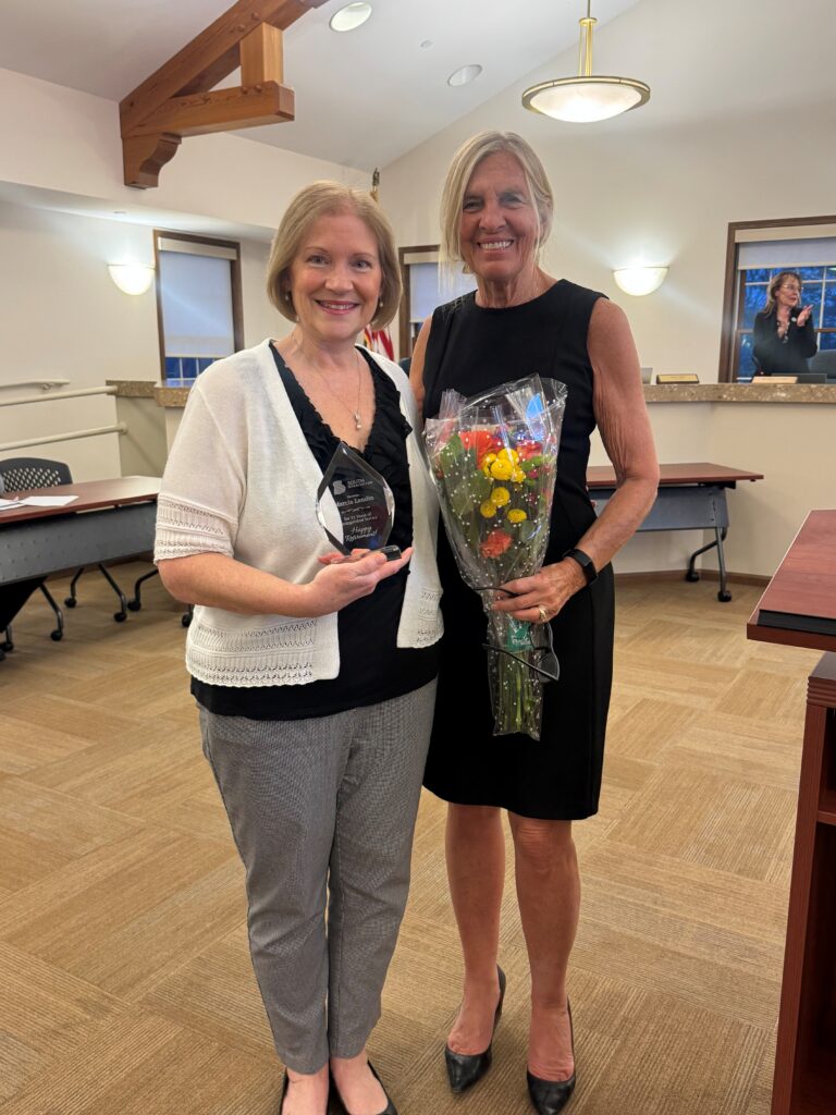 Employee Marcia Landin and Mayor McCombie at Village Board meeting being recognized with an award
